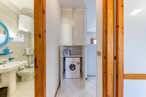 ein Badezimmer mit einer Waschmaschine und einem Waschbecken in der Unterkunft Appartamento climatizzato con vista mare a 50 m dalla spiaggia in Lido Marini