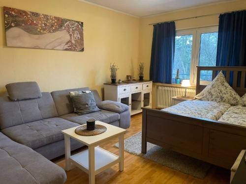 ein Wohnzimmer mit einem Sofa und einem Tisch in der Unterkunft Moderne Zimmer im Grünen, mit Park- und Meer-Nähe in Bad Zwischenahn