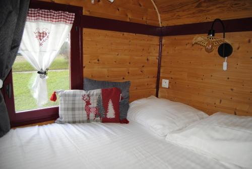 a bedroom with a bed in a room with a window at La roulotte belle fleur in Saint-Nabord