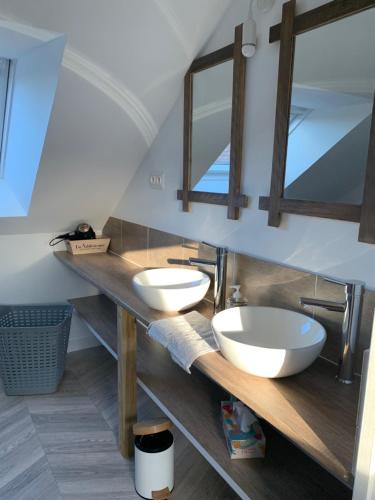 a bathroom with two sinks and two mirrors at Gite de Groupe Aux Instants Partagés in Fontenay-sur-Vègre