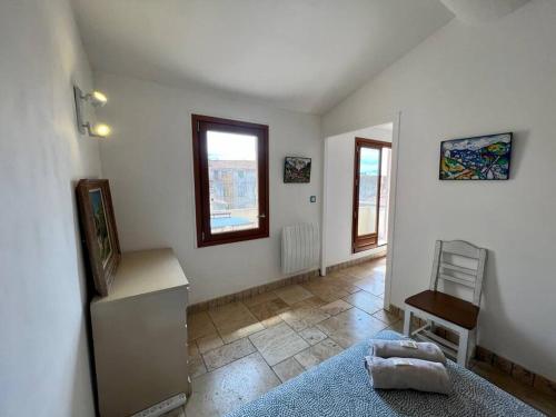 - un salon avec des murs blancs, une table et une fenêtre dans l'établissement Appart. avec terrasse au cœur du centre historique, à Aix-en-Provence