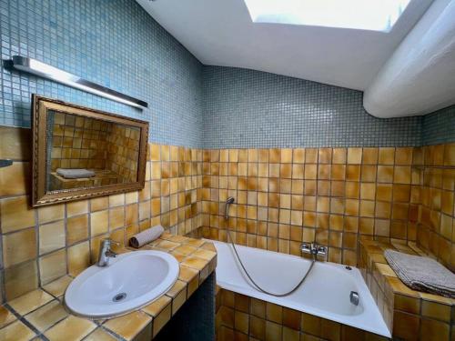une salle de bain avec un lavabo, une baignoire et un miroir dans l'établissement Appart. avec terrasse au cœur du centre historique, à Aix-en-Provence