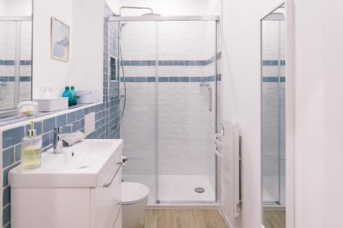 a white bathroom with a shower and a sink at Autour du Monde #Netflix #Centre historique #Calme in Joigny