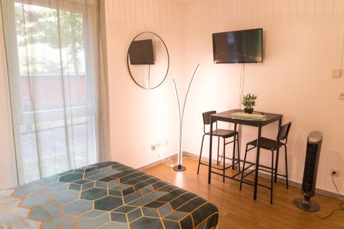 Schlafzimmer mit einem Bett, einem Tisch und einem Spiegel in der Unterkunft Charmant studio avec Parking privé - Proche Part-Dieu in Villeurbanne