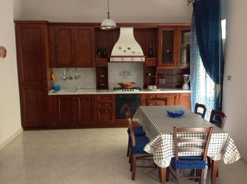 a kitchen with wooden cabinets and a table with chairs at Giocasa in Gioiosa Marea