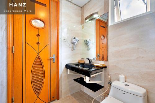 W łazience znajduje się umywalka, toaleta i lustro. w obiekcie HANZ Happy 2 Hotel w Ho Chi Minh