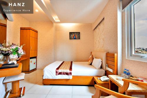 sypialnia z łóżkiem i biurkiem w pokoju w obiekcie HANZ Happy 2 Hotel w Ho Chi Minh