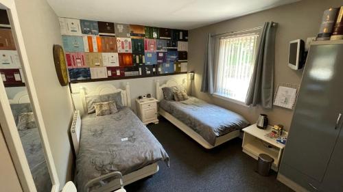um pequeno quarto com 2 camas e uma janela em The Gables Whisky B&B em Dufftown