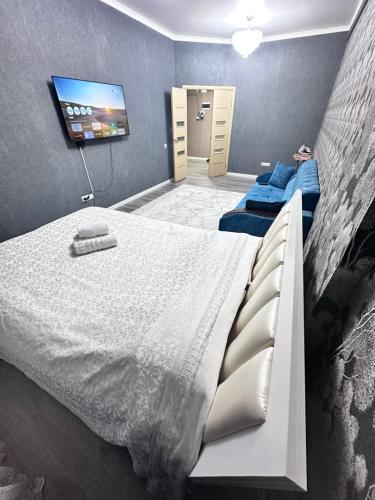 een slaapkamer met een bed en een flatscreen-tv bij Goktash in Bisjkek