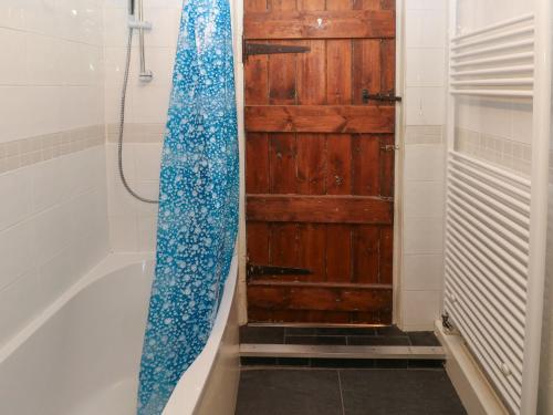 a bathroom with a bath tub with a wooden door at Rose Villa in Builth Road