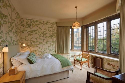Schlafzimmer mit einem Bett, einem Schreibtisch und Fenstern in der Unterkunft Rhodes House, Oxford in Oxford