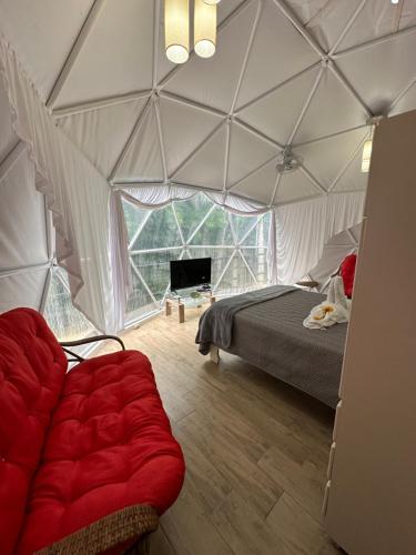 a room with a bed and a couch in a tent at Glamping Hope Garden in Sarapiquí