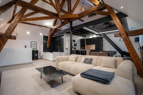 a living room with a couch and a table at Le Saint-André - Clim - Loft romantique avec Jacuzzi in Buxy