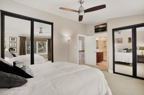 Habitación blanca con 2 camas y ventilador de techo. en Private 4-bedroom steps to lake, en Burlington