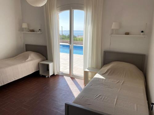 - une chambre avec 2 lits et une vue sur la piscine dans l'établissement Les Issambres - 8 pers, piscine privée, belle vue mer, aux Issambres