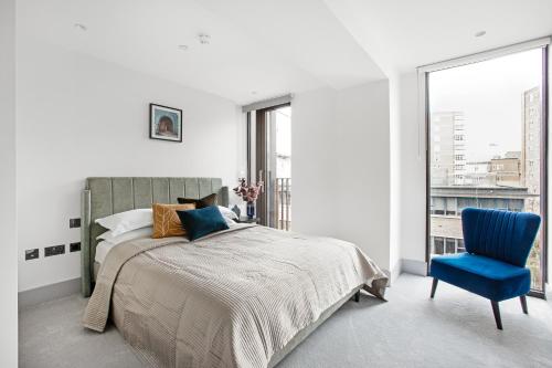 a bedroom with a bed and a blue chair at Stunning 3 Bedroom Penthouse Private Terrace AC in London