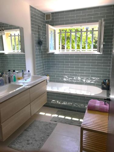 une salle de bain avec une baignoire et un lavabo et une baignoire dans l'établissement Les Issambres - 8 pers, piscine privée, belle vue mer, aux Issambres