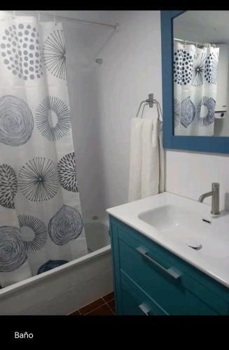 a bathroom with a sink and a shower curtain at Apartamento Marbi in Les Cases d'Alcanar
