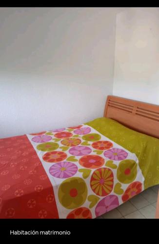 a bed with a bedspread with flowers on it at Apartamento Marbi in Les Cases d'Alcanar