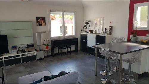 een woonkamer met een tafel en een keuken bij Maison familiale proche des JO et Disney in Vaires-sur-Marne