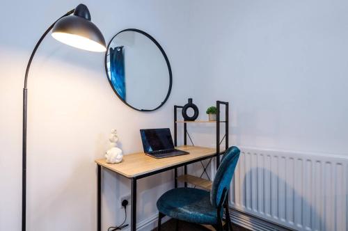 escritorio con ordenador portátil y silla con espejo en Cozy and Stylish 1 Bedroom Flat in Warrington en Warrington