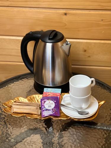 a tea pot and a cup on a table at Порядна Ґаздиня in Yaremche
