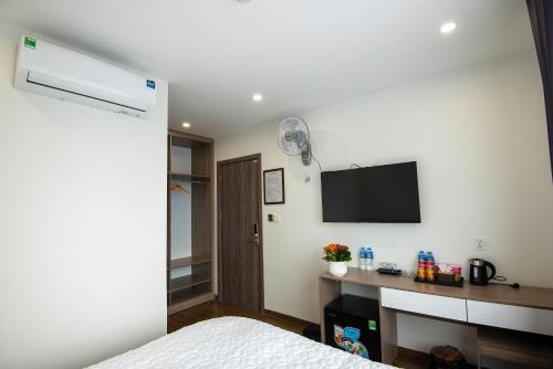 1 dormitorio con 1 cama y TV en la pared en KHÁCH SẠN ANH TÚ, en Lạng Sơn
