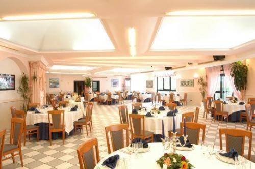 Hotel Lo Smeraldo في تْشيستيرنِنو: غرفة طعام مع طاولات وكراسي في مطعم
