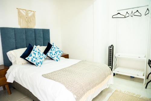 a bedroom with a bed with a blue headboard at Hotel Bungalows Casa Blanca in Tenancingo de Degollado