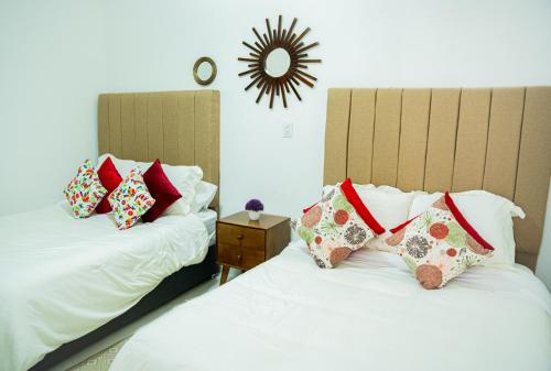 two beds with pillows on them in a bedroom at Hotel Bungalows Casa Blanca in Tenancingo de Degollado