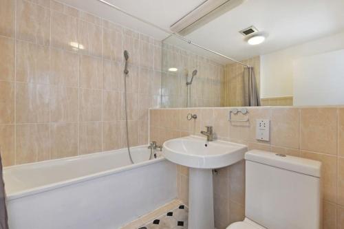 a bathroom with a sink and a tub and a toilet at 2 Bed Apartment- Central London in London