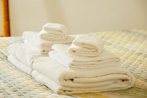 uma pilha de toalhas sentadas numa cama em 6/4 de Sado em Setúbal