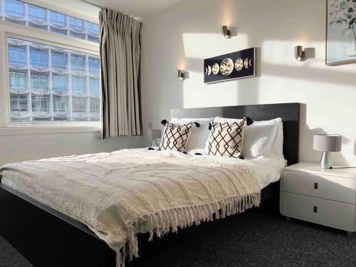 a bedroom with a bed with pillows and a window at 2 Bed Apartment- Central London in London