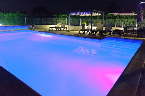 a swimming pool with blue and pink lights in it at Logis Le Mistral - Montélimar Sud in Châteauneuf-du-Rhône