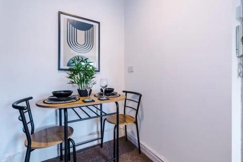 沃靈頓的住宿－Cozy and Stylish 1 Bedroom Flat in Warrington，餐桌,椅子和植物