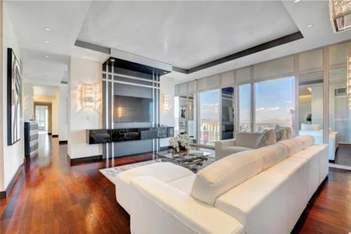a living room with a white couch and a fireplace at High-Rise 2 Bedroom-Apartment With Breathtaking Views in Las Vegas