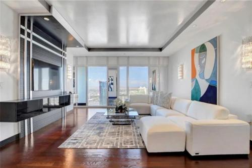 a living room with a white couch and a tv at High-Rise 2 Bedroom-Apartment With Breathtaking Views in Las Vegas