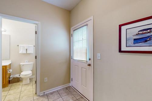 a bathroom with a toilet and a window at Snorkel Way in Myrtle Beach