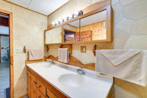 La salle de bains est pourvue d'un lavabo et d'un miroir. dans l'établissement Authentic Log Cabin in Pineville about 2 Mi to River!, 