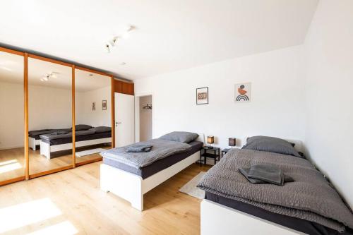 1 dormitorio con 2 camas y espejo en AM01 Haus mit Garten & Terrasse! en Groß-Gerau