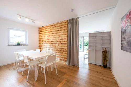 a dining room with a white table and white chairs at AM01 Haus mit Garten & Terrasse! in Groß-Gerau