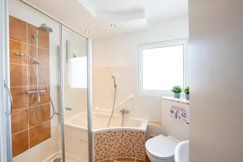 a bathroom with a shower and a toilet and a tub at AM01 Haus mit Garten & Terrasse! in Groß-Gerau