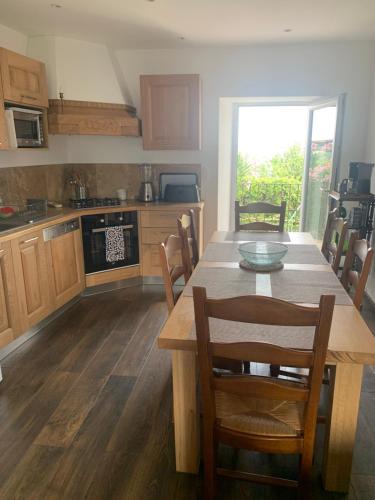 une cuisine avec une table en bois et des chaises ainsi qu'une salle à manger dans l'établissement CASA SANTOLINI, à Poggio-Mezzana