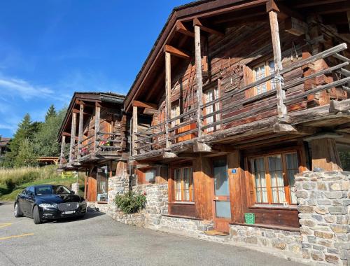 a car parked in front of a wooden building at Mazot Agora & Spa Family Trip - Chalet Ouest R+1 in Salvan