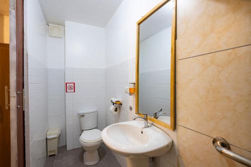 a bathroom with a sink and a toilet and a mirror at Casa Samaykuy in Ayacucho