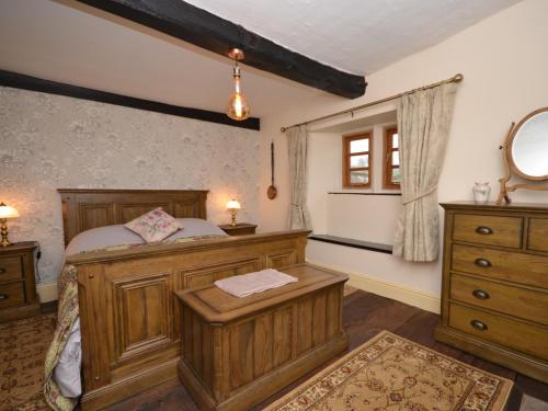a bedroom with a wooden bed and a window at 3 bed in Coleford 52148 in Bream