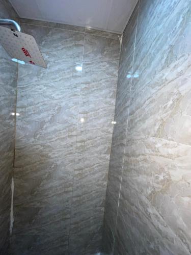 a shower with a stone wall in a bathroom at MPH in Lagos