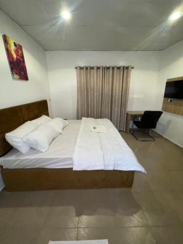 a bedroom with a large bed with white sheets and pillows at MPH in Lagos