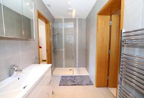 een badkamer met een douche en een wastafel bij Luxury Detached Home Close to Strangford Lough in Killinchy