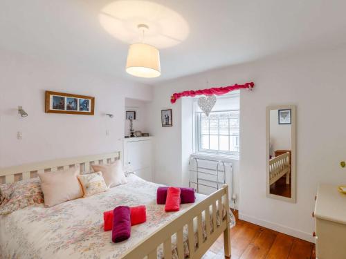 um quarto com uma cama com almofadas vermelhas em 2 bed in Brixham 82723 em Brixham
